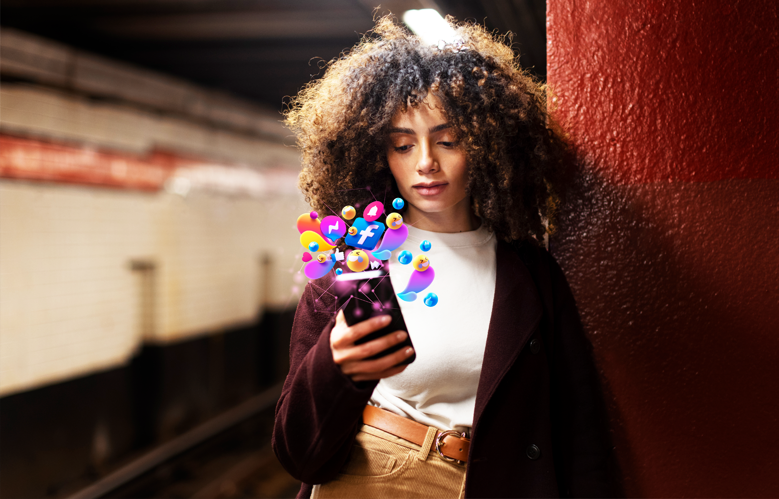 Mulher olhando o celular enquanto ícones de redes sociais aparecem ao redor do aparelho, representando presença digital e interação online.