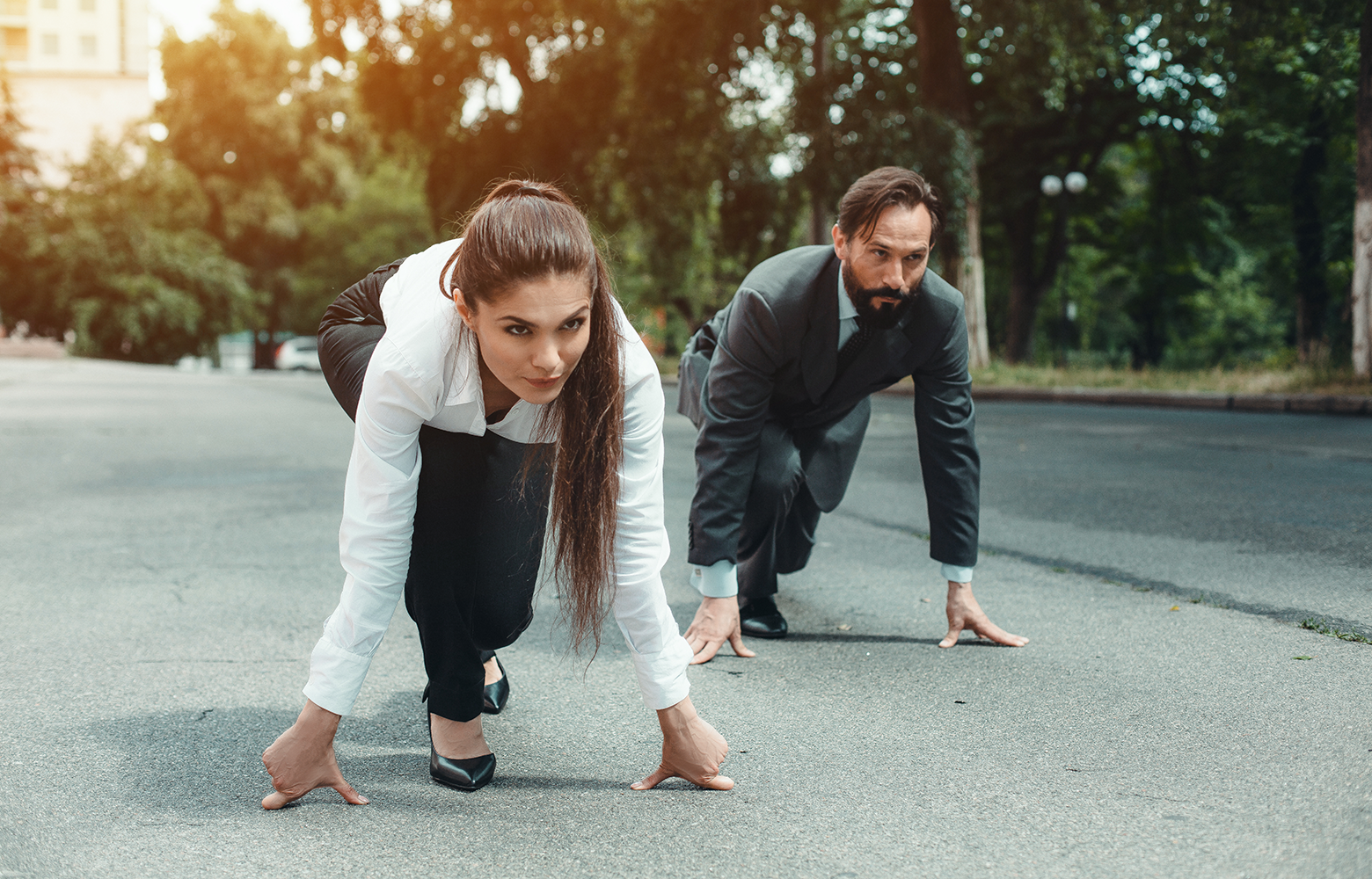 Dois profissionais posicionados como corredores na linha de largada, prontos para iniciar uma corrida. A imagem simboliza a busca por diferencial competitivo e as estratégias que permitem às empresas se destacar em mercados concorridos.