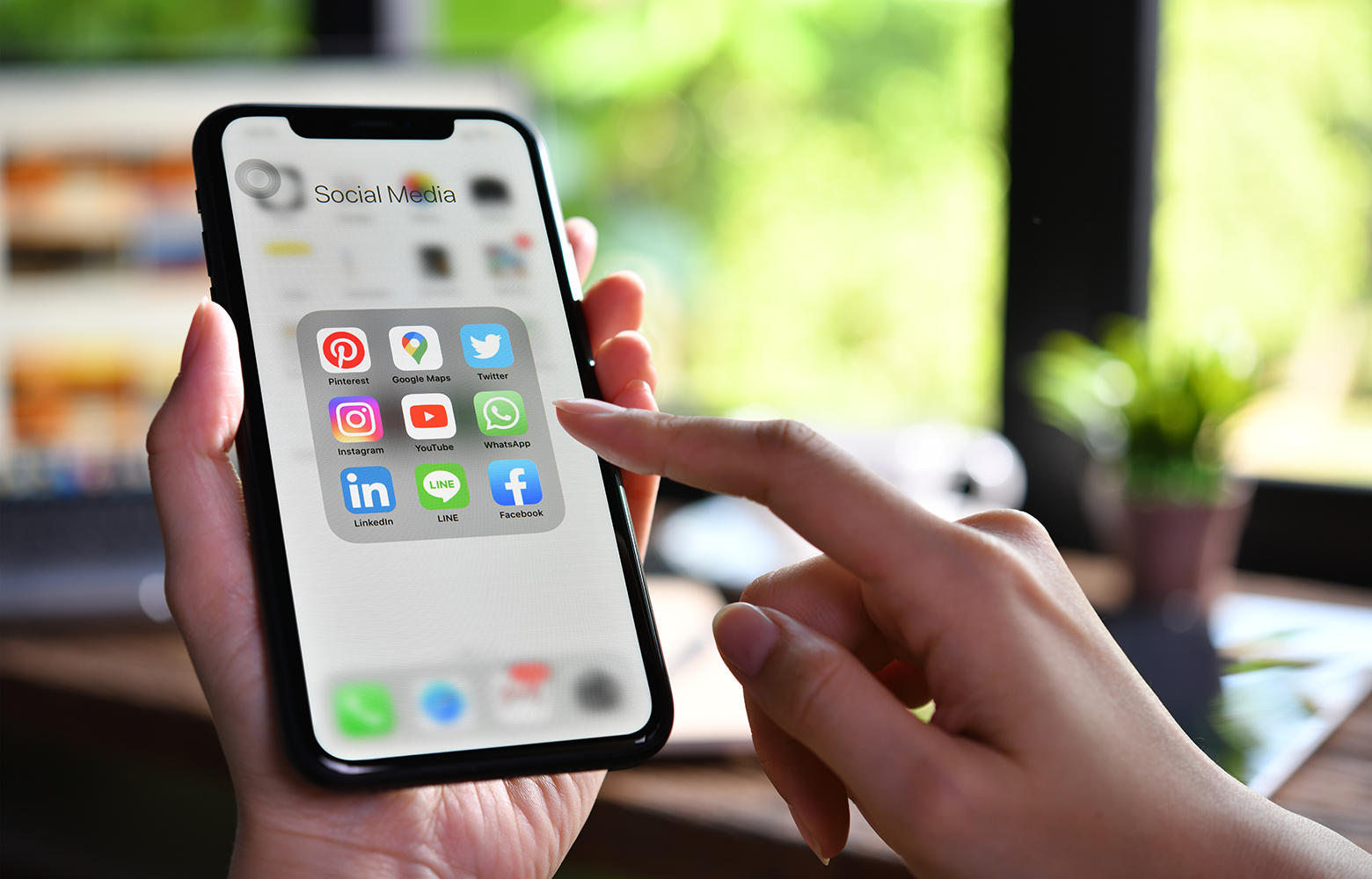 Pessoa utilizando um smartphone com aplicativos de redes sociais na tela, representando o posicionamento de marca no digital e a comunicação das empresas nas plataformas sociais.